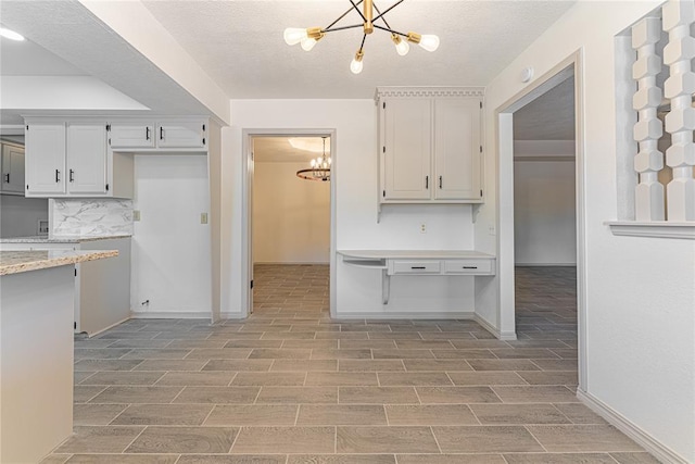 11800 Shasta Ln, Oklahoma City, OK 73162 - kitchen with baseboards, a notable chandelier, and wood tiled floor