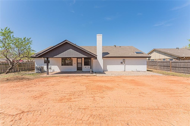 11800 Shasta Ln, Oklahoma City, OK 73162 - back of house featuring brick siding, a fenced backyard, and a chimney