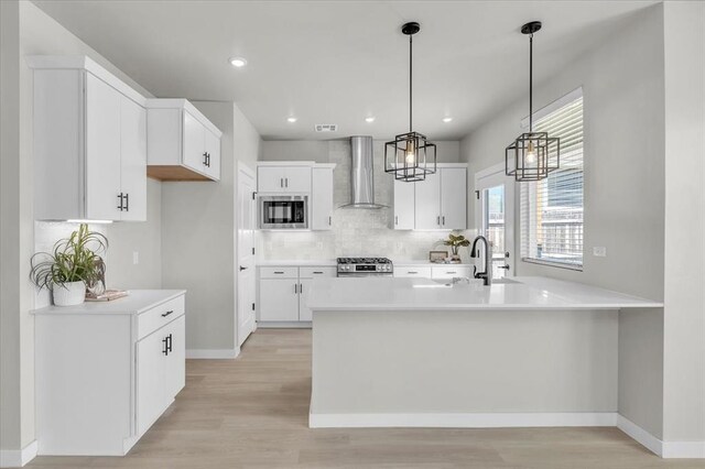 508 NW 175th St, Edmond, OK 73012 - kitchen featuring wall chimney exhaust hood, stainless steel microwave, range, a sink, and a peninsula