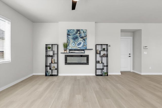 508 NW 175th St, Edmond, OK 73012 - living area with wood finished floors, a glass covered fireplace, ceiling fan, and baseboards