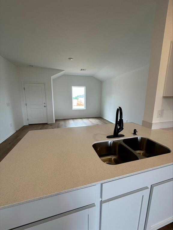 794 SW 11th St, Newcastle, OK 73065 - kitchen featuring a sink, vaulted ceiling, open floor plan, and white cabinetry