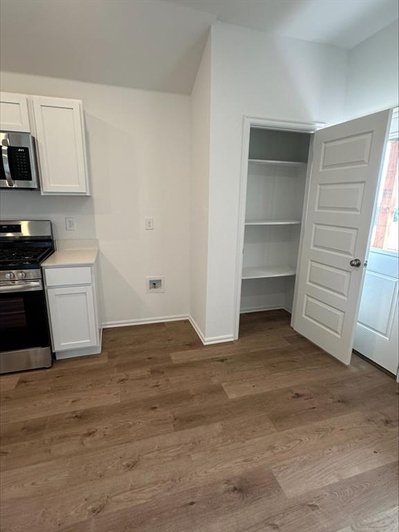 794 SW 11th St, Newcastle, OK 73065 - kitchen with stainless steel appliances, white cabinetry, wood finished floors, baseboards, and light countertops