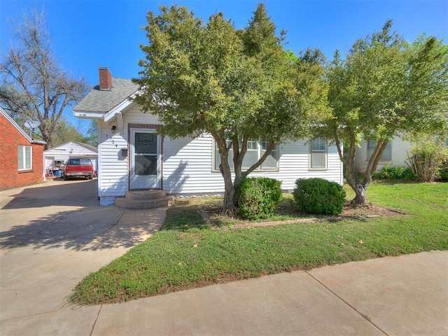 obstructed view of property with a chimney, driveway, and a front lawn
