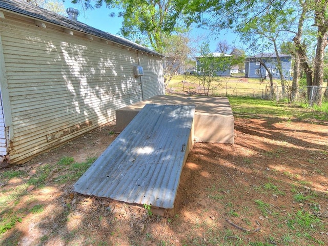 entry to storm shelter featuring fence