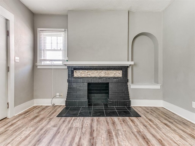 details featuring baseboards, wood finished floors, and a fireplace
