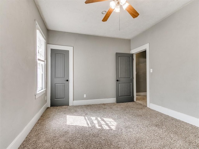 unfurnished bedroom featuring baseboards, multiple windows, and carpet