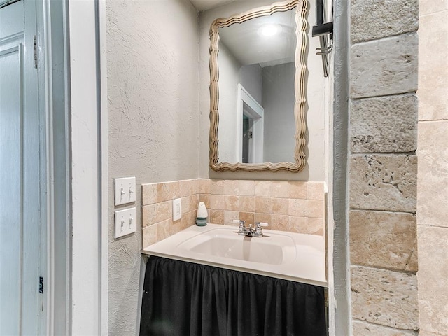 bathroom with a textured wall and a sink