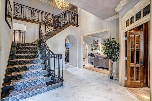 5100 Wisteria Dr, Oklahoma City, OK 73142 - stairway with arched walkways, ornamental molding, a high ceiling, marble finish floor, and baseboards