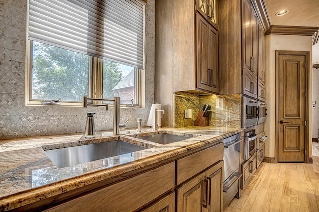 5100 Wisteria Dr, Oklahoma City, OK 73142 - kitchen featuring tasteful backsplash, light wood-type flooring, ornamental molding, light stone countertops, and brown cabinets