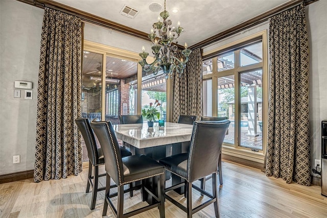 5100 Wisteria Dr, Oklahoma City, OK 73142 - dining space featuring light wood finished floors, a notable chandelier, visible vents, and ornamental molding