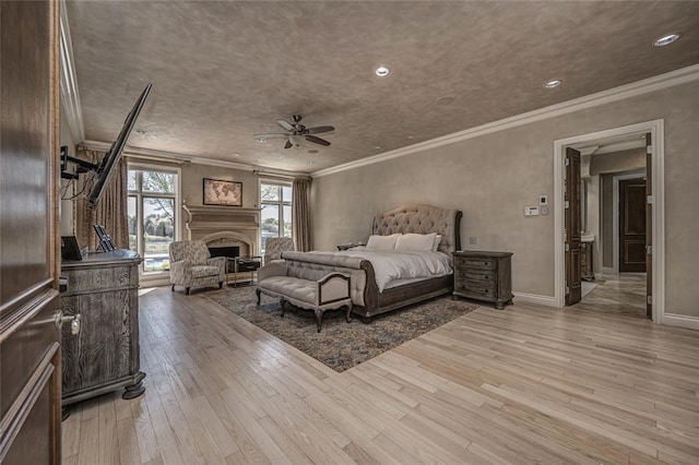 5100 Wisteria Dr, Oklahoma City, OK 73142 - bedroom featuring crown molding, light wood finished floors, a fireplace, and recessed lighting