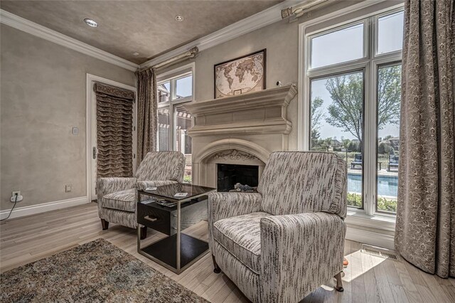 5100 Wisteria Dr, Oklahoma City, OK 73142 - sitting room featuring visible vents, baseboards, ornamental molding, a fireplace, and wood finished floors