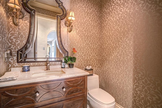 5100 Wisteria Dr, Oklahoma City, OK 73142 - half bathroom with toilet, wallpapered walls, and vanity
