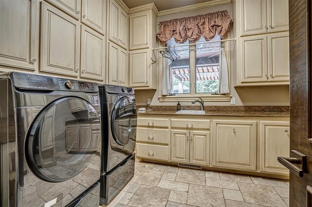 5100 Wisteria Dr, Oklahoma City, OK 73142 - laundry room with washer and clothes dryer, a sink, stone tile flooring, and cabinet space