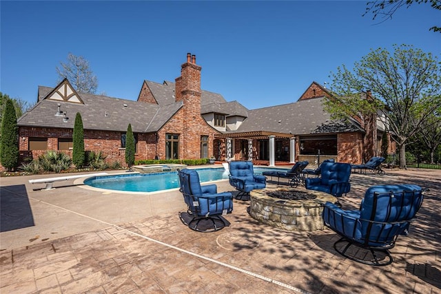 5100 Wisteria Dr, Oklahoma City, OK 73142 - view of swimming pool with a diving board, a patio area, a pool with connected hot tub, and a fire pit