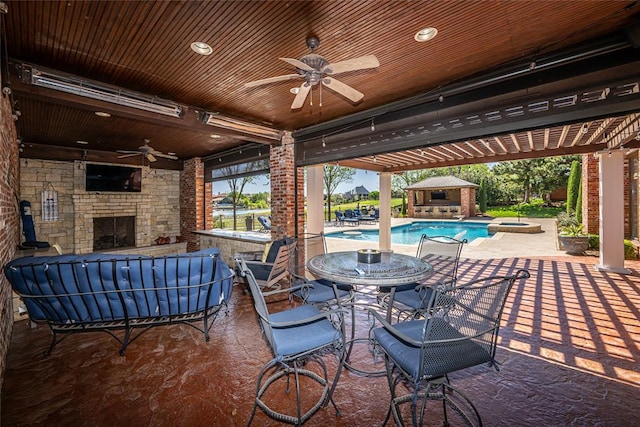 5100 Wisteria Dr, Oklahoma City, OK 73142 - view of patio featuring ceiling fan, a pool with connected hot tub, an outdoor structure, outdoor dining space, and an outdoor stone fireplace