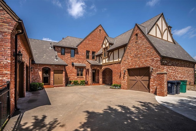 5100 Wisteria Dr, Oklahoma City, OK 73142 - english style home with a garage, brick siding, and driveway