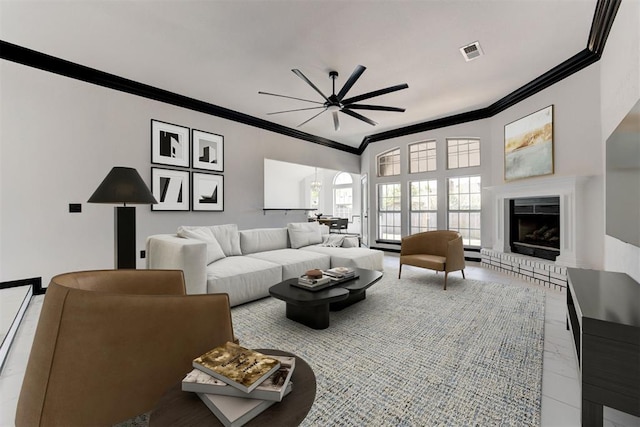 living area with visible vents, crown molding, a ceiling fan, and arched walkways