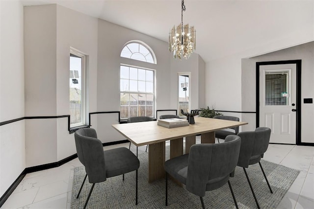 dining space with a chandelier, marble finish floor, and baseboards