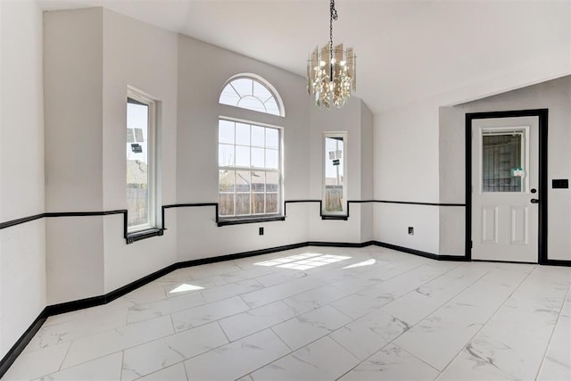 empty room featuring baseboards, a notable chandelier, and marble finish floor
