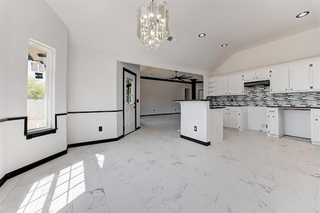 kitchen featuring white cabinetry, recessed lighting, marble finish floor, and vaulted ceiling