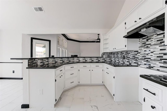 kitchen featuring under cabinet range hood, marble finish floor, dark countertops, a ceiling fan, and a peninsula