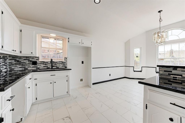 kitchen featuring an inviting chandelier, dark countertops, and marble finish floor