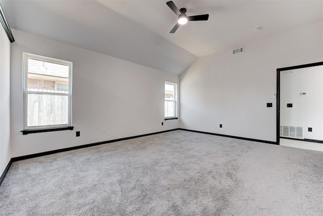 carpeted empty room featuring lofted ceiling, ceiling fan, and baseboards
