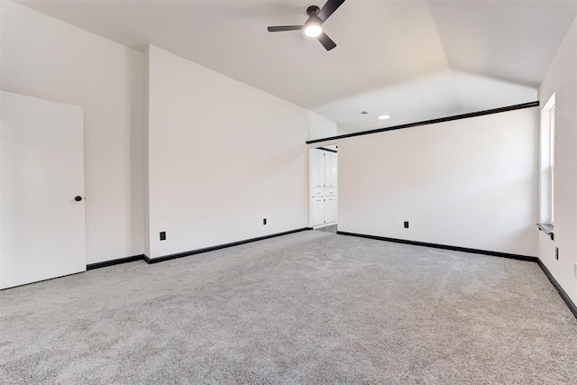 interior space featuring carpet flooring, baseboards, ceiling fan, and lofted ceiling