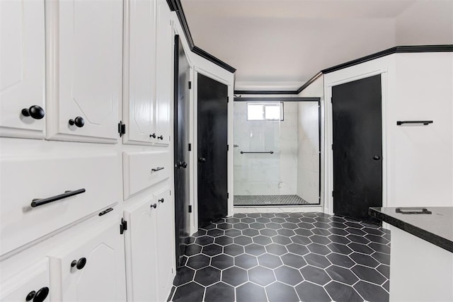 bathroom with a shower stall and tile patterned floors