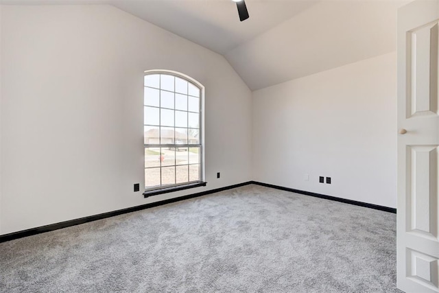 empty room featuring baseboards, a ceiling fan, carpet floors, and lofted ceiling