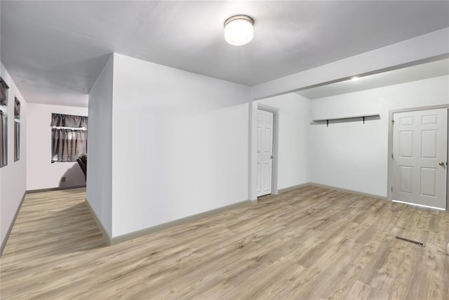 interior space with light wood finished floors, visible vents, and baseboards