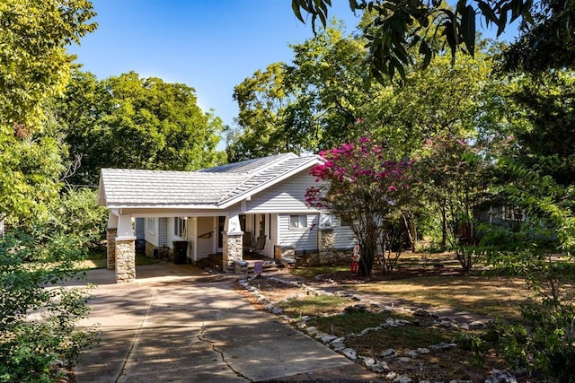 view of front facade with driveway, stone siding, and an attached carport