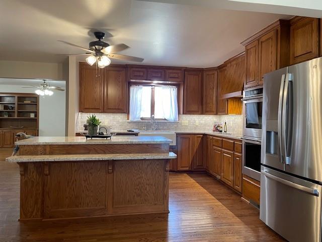 401 Memorial Dr, Okarche, OK 73762 - kitchen featuring a center island, appliances with stainless steel finishes, a ceiling fan, and backsplash