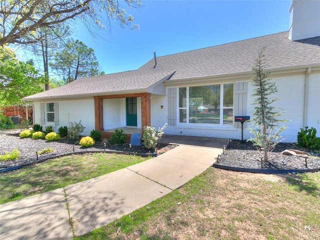 1804 Guilford Ln, Nichols Hills, OK 73120 - ranch-style home featuring roof with shingles, brick siding, a chimney, and a front lawn