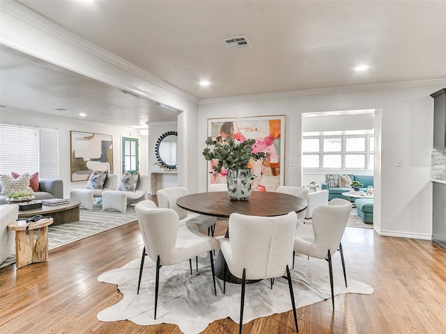 1804 Guilford Ln, Nichols Hills, OK 73120 - dining space featuring crown molding, visible vents, light wood-style floors, and a healthy amount of sunlight