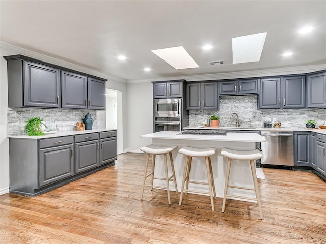 1804 Guilford Ln, Nichols Hills, OK 73120 - kitchen with visible vents, crown molding, stainless steel appliances, backsplash, and a skylight