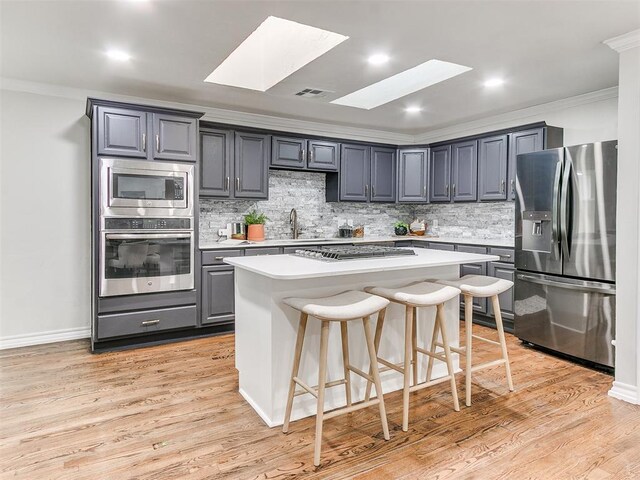 1804 Guilford Ln, Nichols Hills, OK 73120 - kitchen featuring a skylight, ornamental molding, visible vents, and stainless steel appliances
