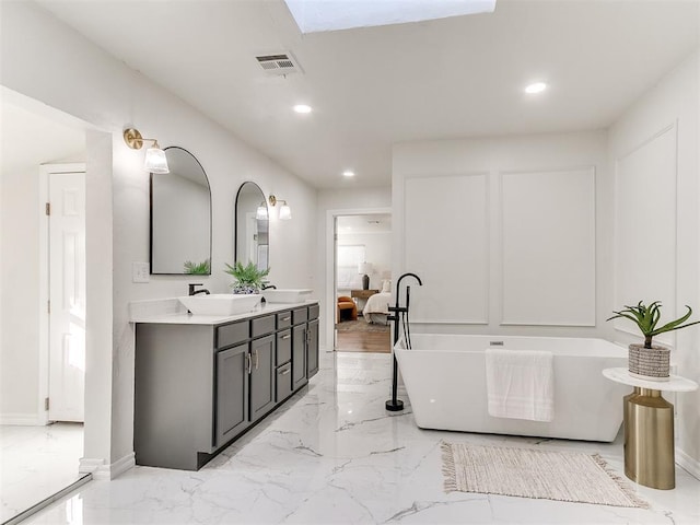 1804 Guilford Ln, Nichols Hills, OK 73120 - bathroom with a freestanding tub, double vanity, recessed lighting, marble finish floor, and a sink
