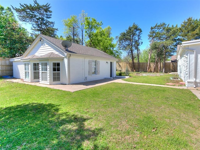 1804 Guilford Ln, Nichols Hills, OK 73120 - rear view of house featuring a shingled roof, a patio area, a lawn, fence, and brick siding