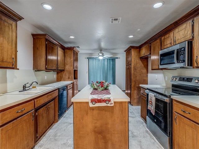 kitchen featuring visible vents, a center island, appliances with stainless steel finishes, a sink, and brown cabinets
