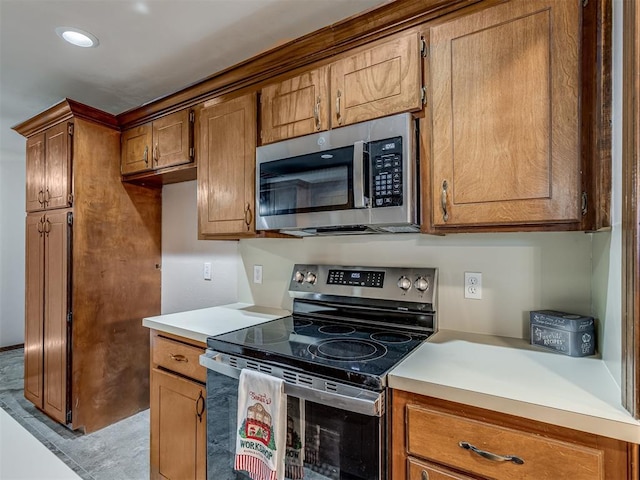 kitchen featuring brown cabinets, light countertops, and appliances with stainless steel finishes