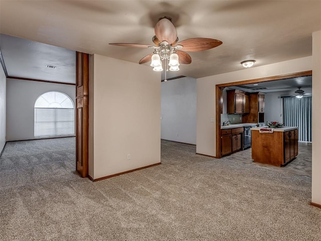 kitchen with baseboards, light colored carpet, light countertops, and ceiling fan
