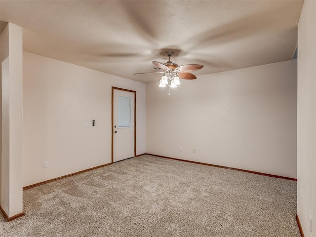 empty room featuring light colored carpet, baseboards, and ceiling fan