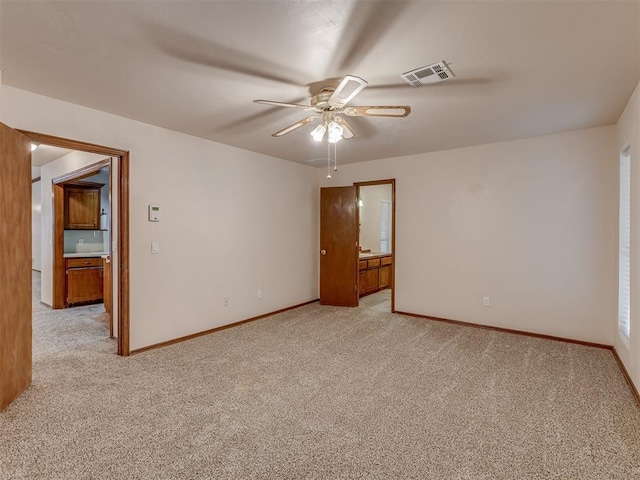 spare room with light carpet, baseboards, a ceiling fan, and visible vents