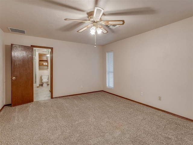 spare room featuring visible vents, ceiling fan, light carpet, and baseboards