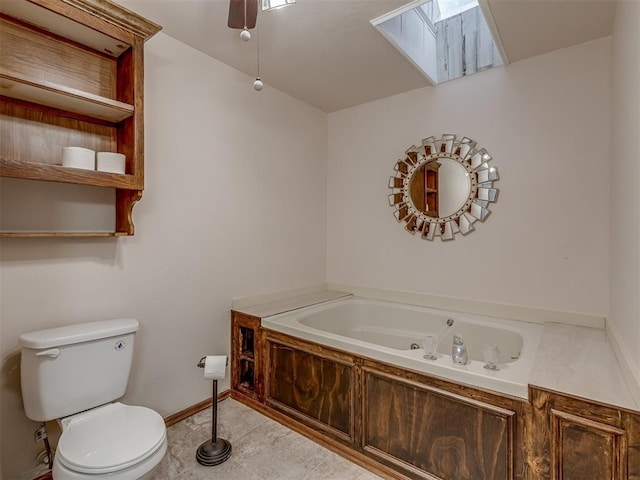full bath featuring a whirlpool tub, a ceiling fan, toilet, and a skylight