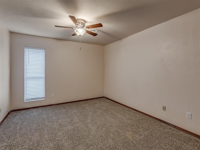 carpeted spare room featuring ceiling fan, baseboards, and plenty of natural light