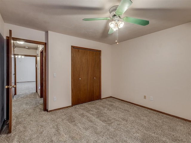 unfurnished bedroom featuring a closet, baseboards, a ceiling fan, and carpet