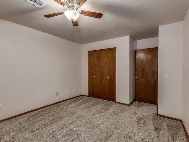unfurnished bedroom with light carpet, visible vents, baseboards, and a closet